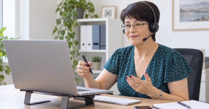 A woman wearing a headset talks during a computer interview in a realistic office.
