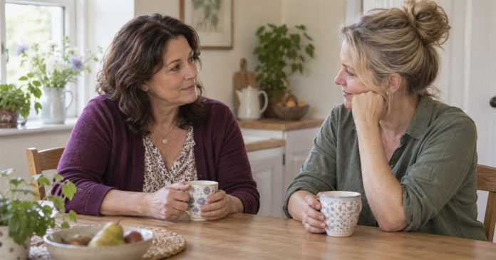 A supportive conversation at home Two women talking calmly over tea at a home kitchen table.