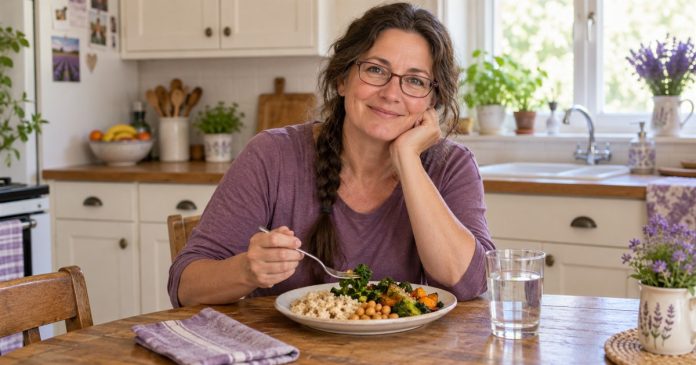 Taking an ordinary workday meal break Woman enjoying a simple lunch and water at her home kitchen table.